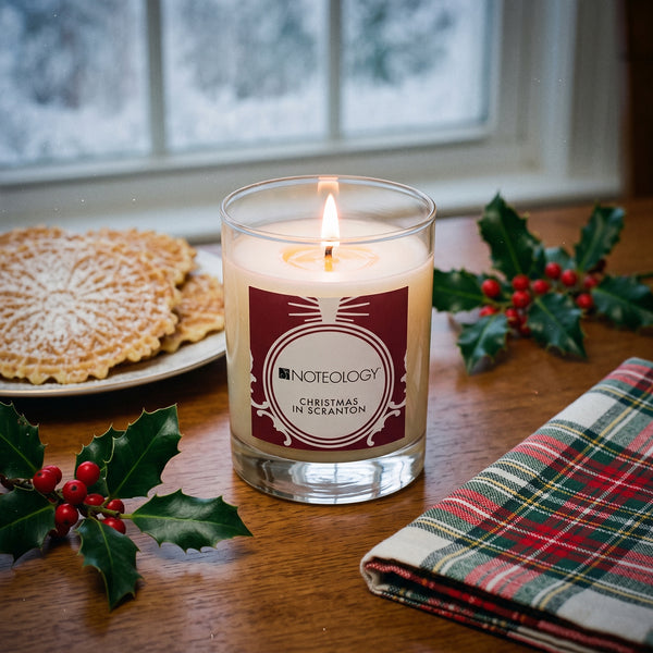 Christmas in Scranton Candle burning on a holiday dining table by a frosted window on a snowy evening | Noteology