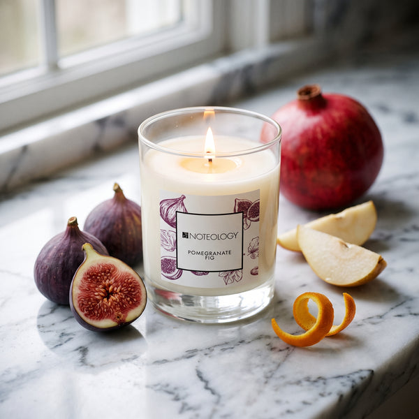 Pomegranate Fig Candle burning on a marble counter in soft daylight | Noteology