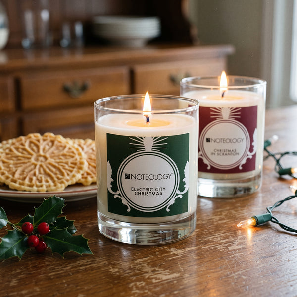 Scranton Candle Duo burning on a worn wooden sideboard in a lived-in dining room on a winter afternoon | Noteology